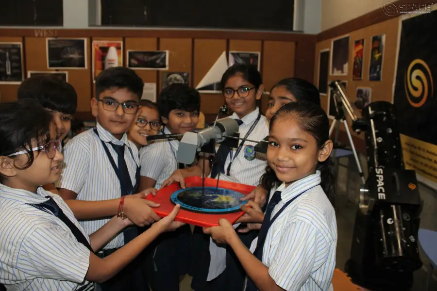 Primary students holding a model in the astronomy lab